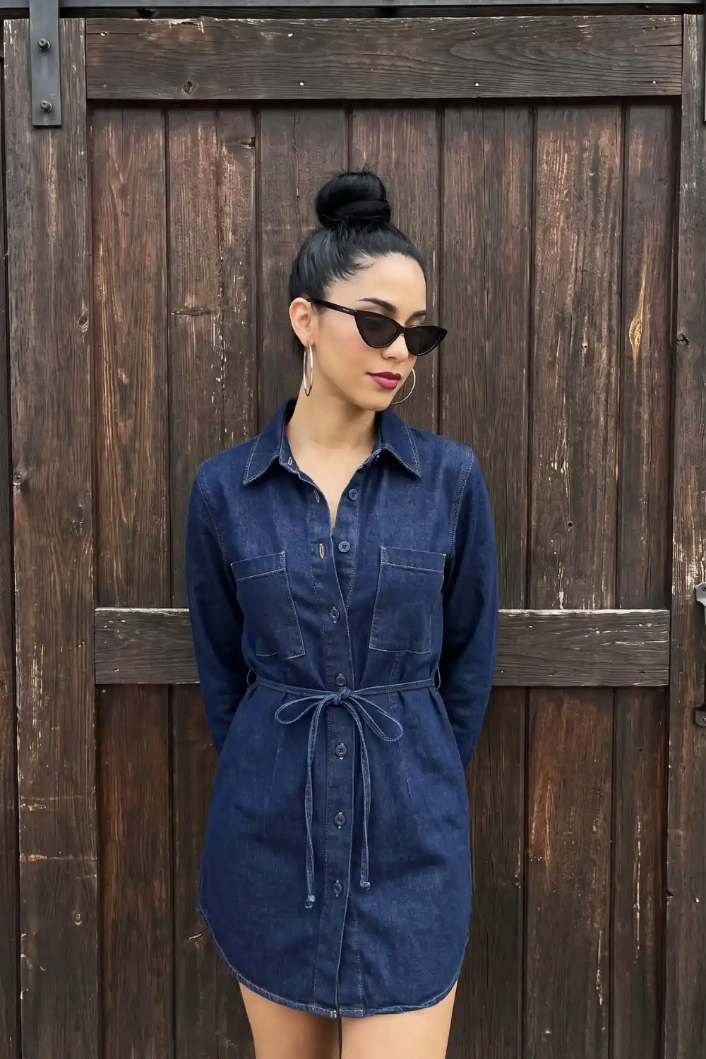 Woman wearing dark wash navy denim mini shirt dress with tie waist