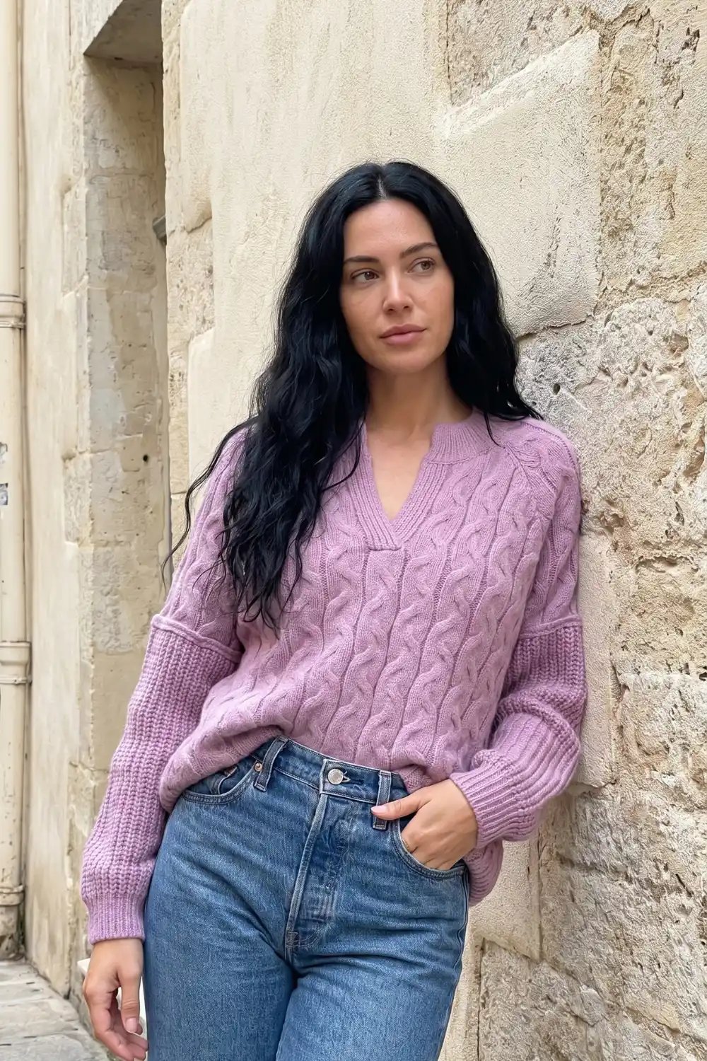 Woman wearing dusty pink V-neck cable knit sweater