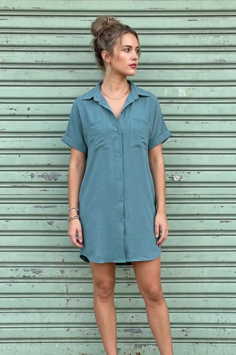 Woman wearing dusty teal blue short sleeve mini shirt dress with chest pockets