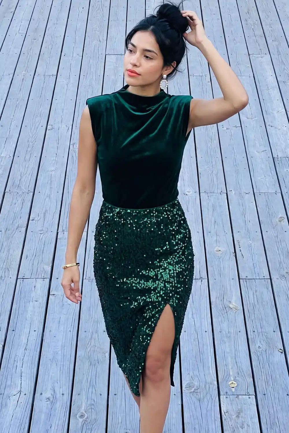 Woman in emerald green velvet top and sequin wrap midi skirt