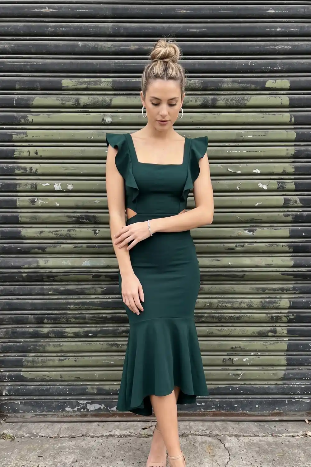 Woman in forest green ruffle sleeve mermaid midi dress