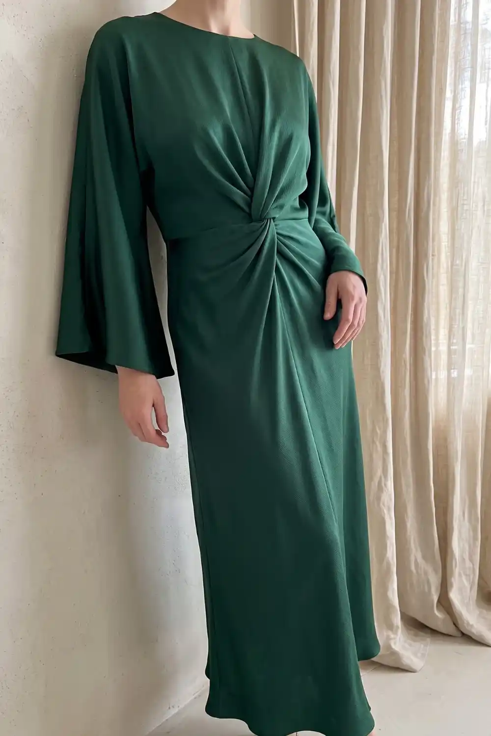 Woman wearing forest green flare sleeve twist knot waist maxi dress