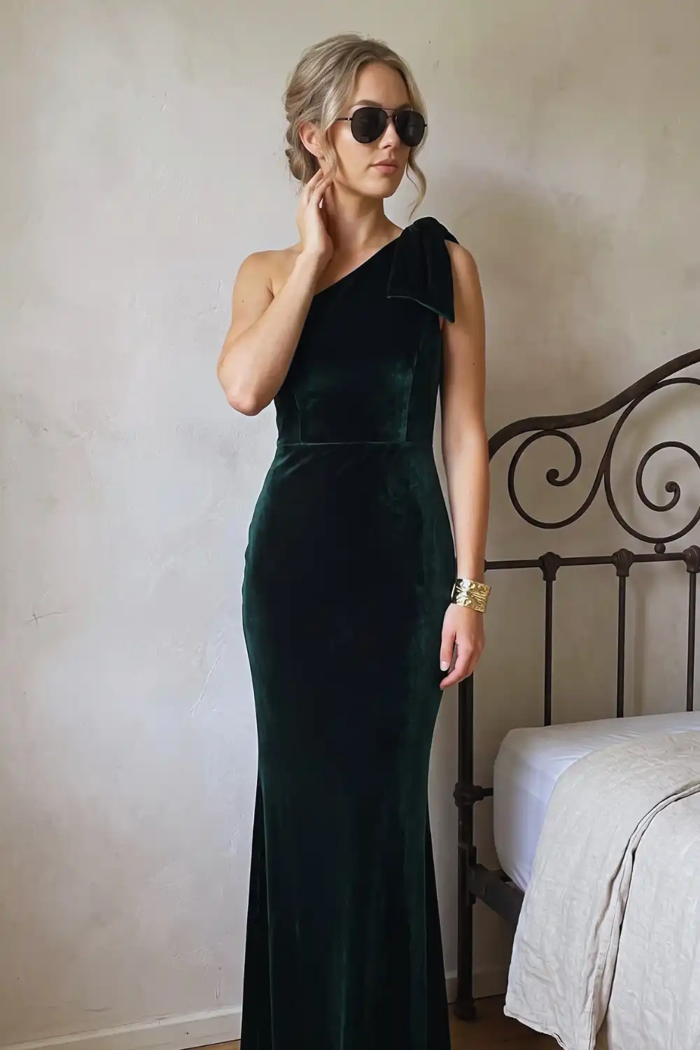Woman in dark green velvet one shoulder bow fishtail maxi dress