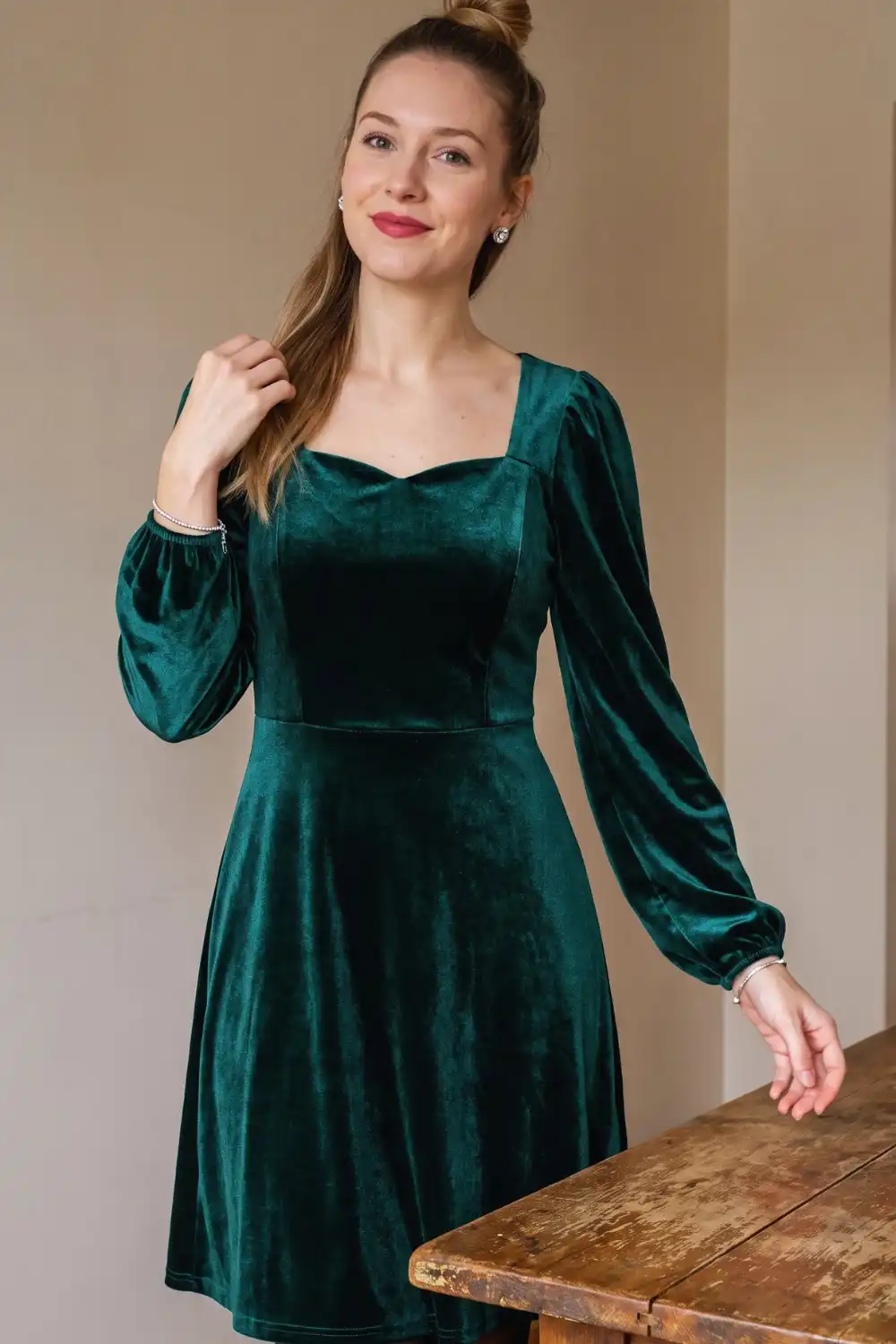 Woman in teal green velvet square neck puff sleeve a-line mini dress