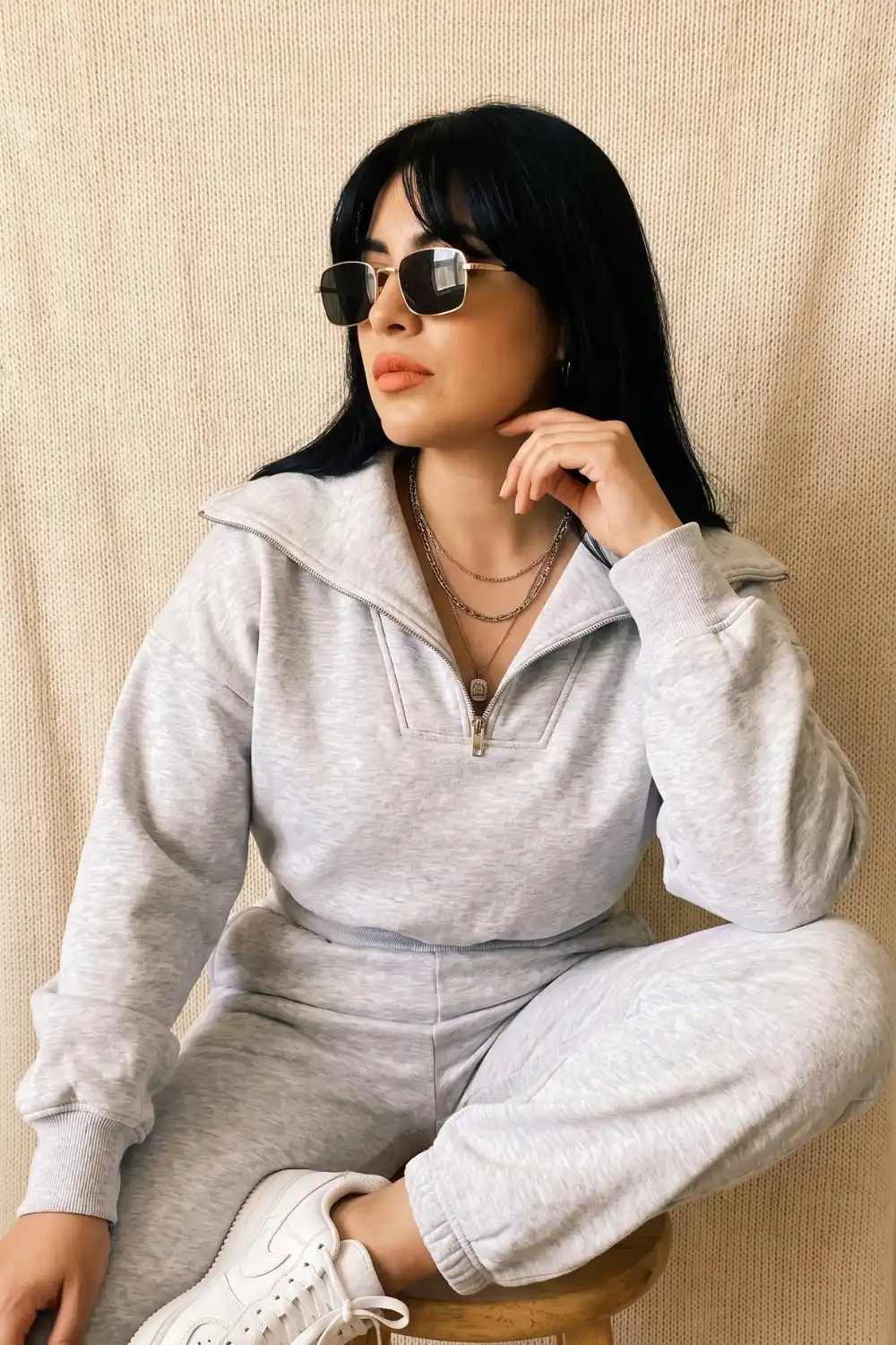 Woman wearing light grey half-zip oversized sweatshirt with matching joggers