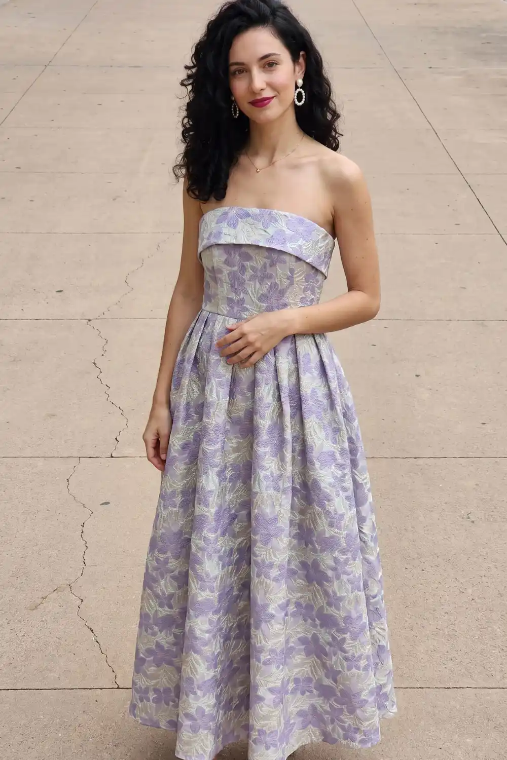 Woman in lavender floral jacquard strapless pleated midi dress