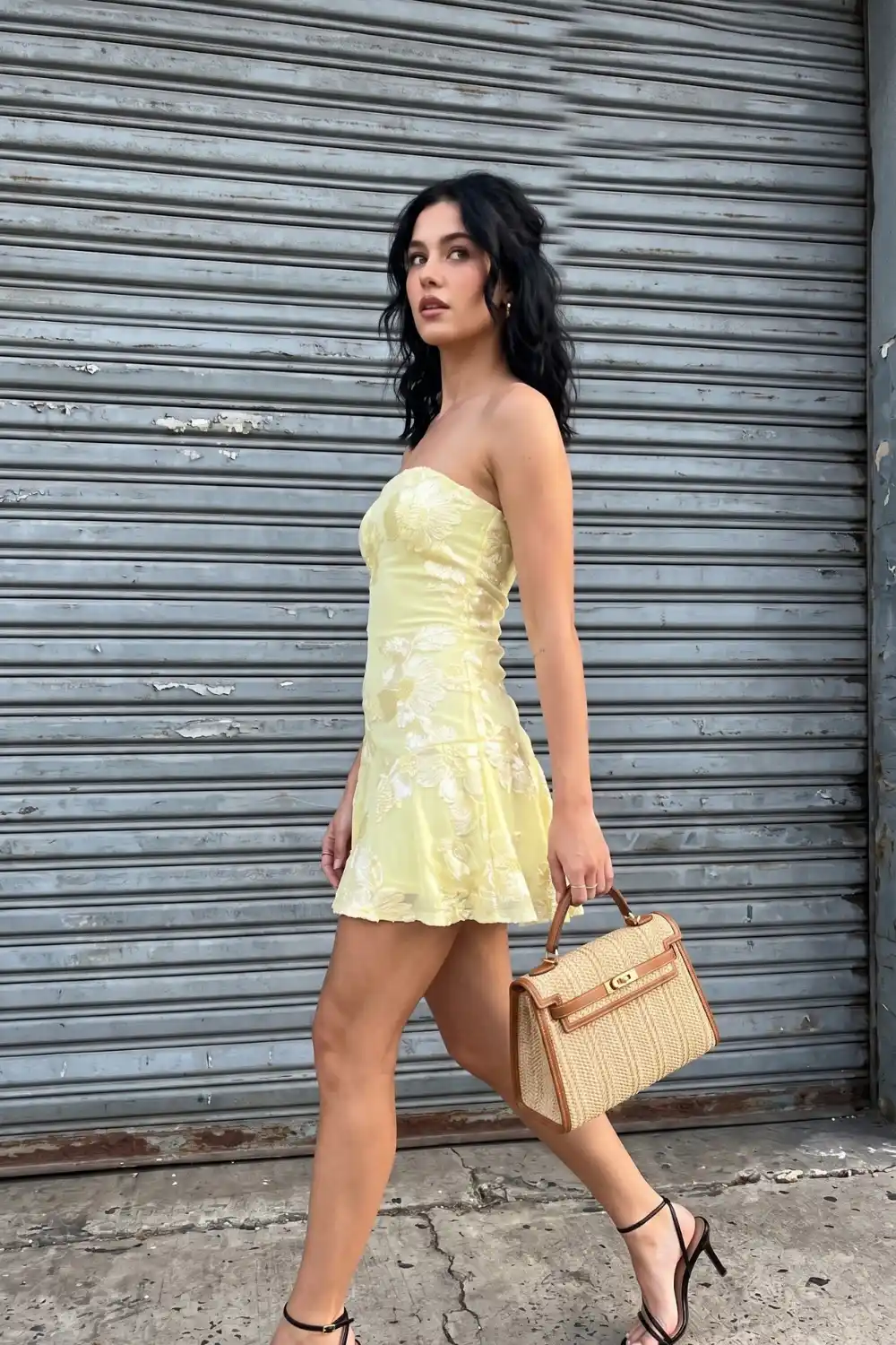 Woman wearing lemon yellow floral embroidered strapless corset mini dress