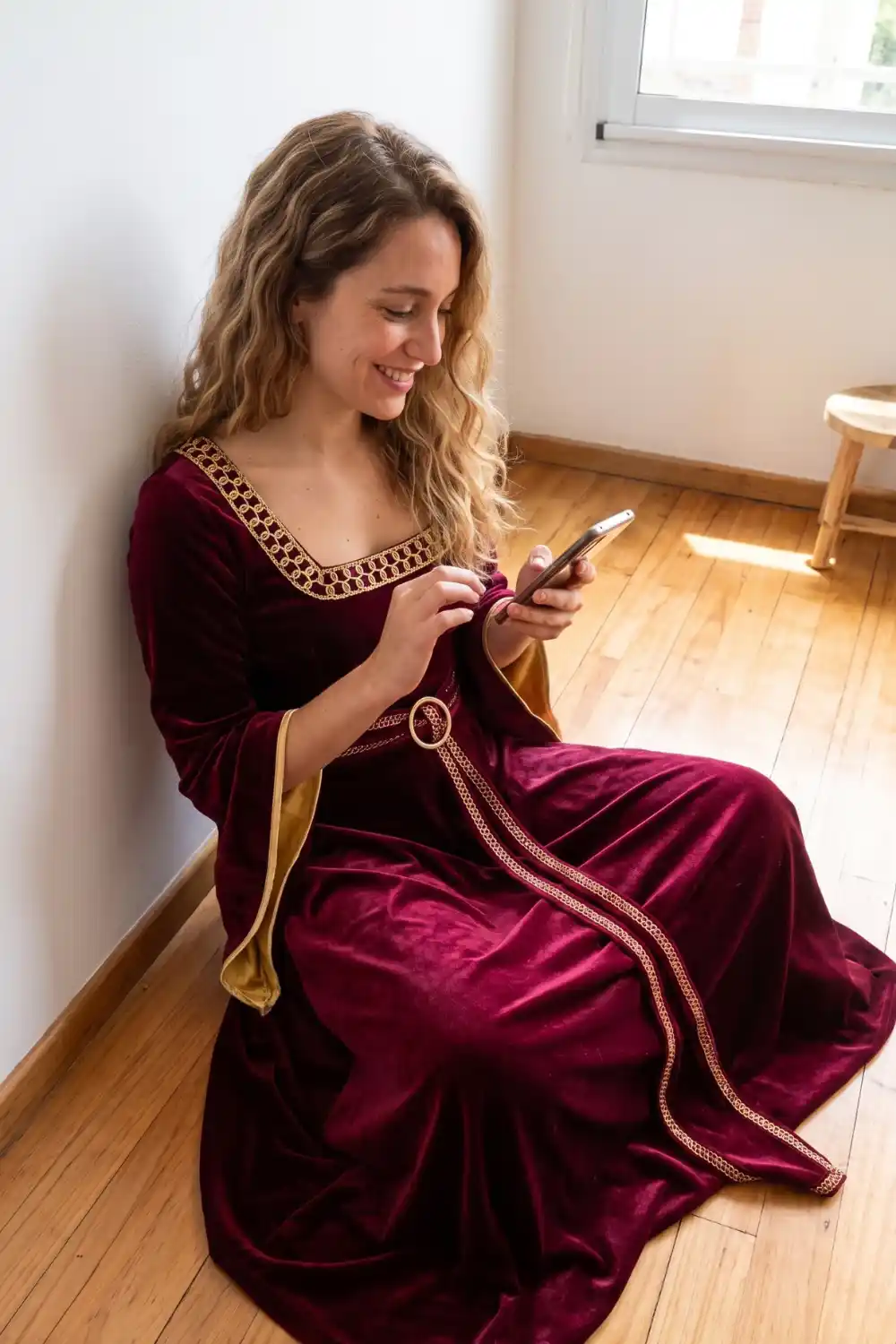 Woman dressed as Mother Gothel from Tangled in burgundy velvet gown with gold trim