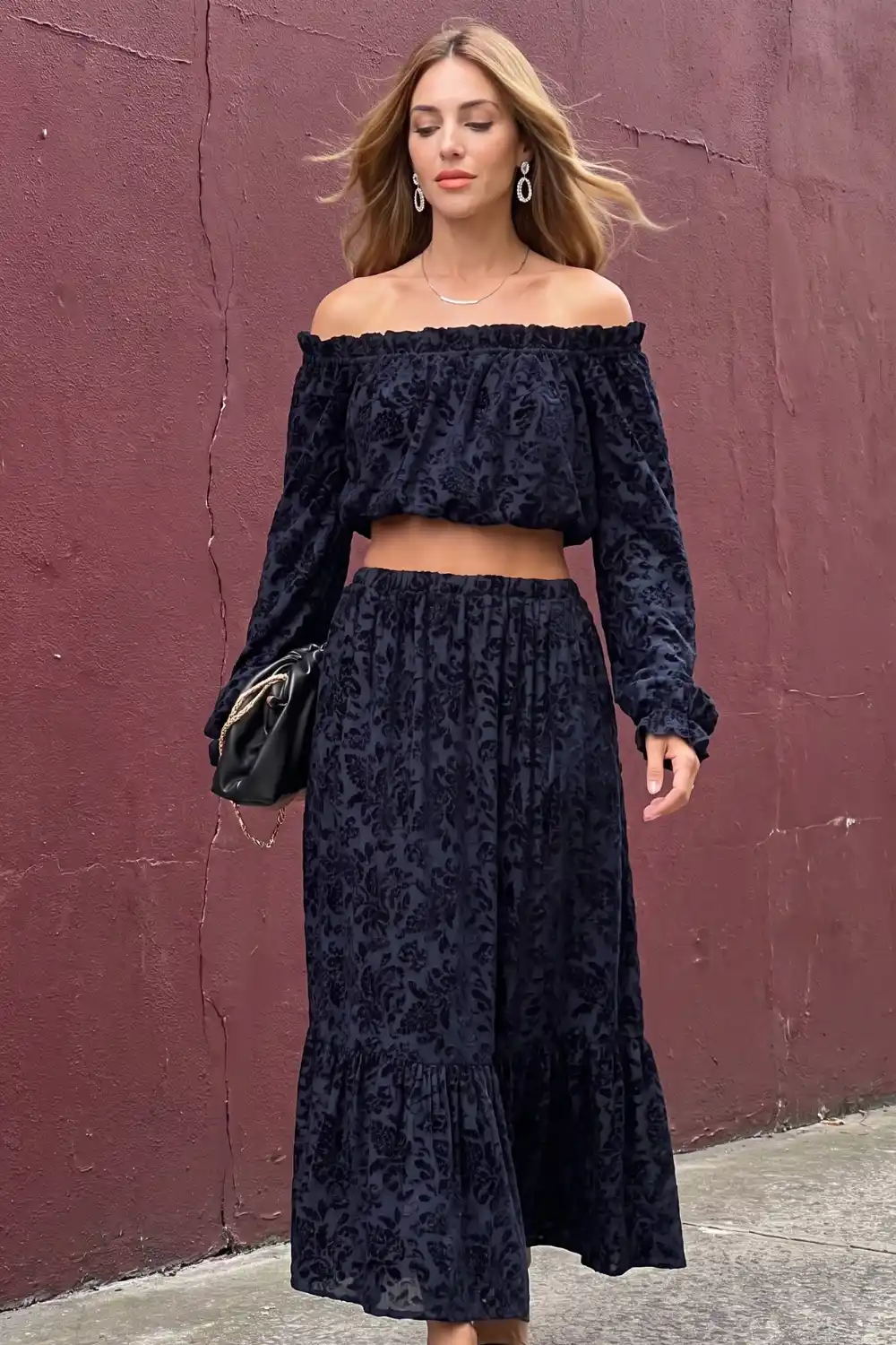 Woman in navy floral burnout velvet off shoulder crop top and maxi skirt set