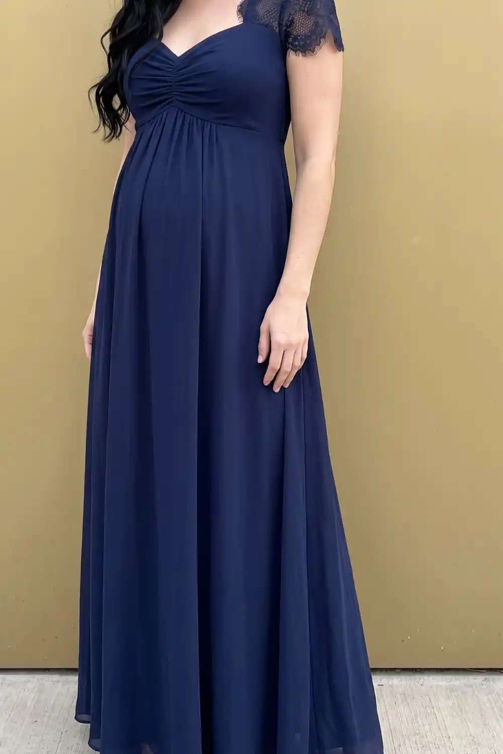 Woman wearing navy lace cap sleeve chiffon maxi dress