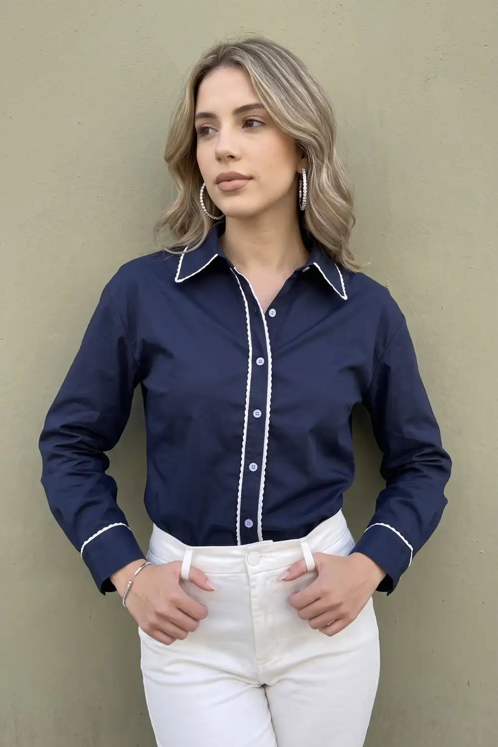 Woman in navy blue white trim button down shirt with white jeans