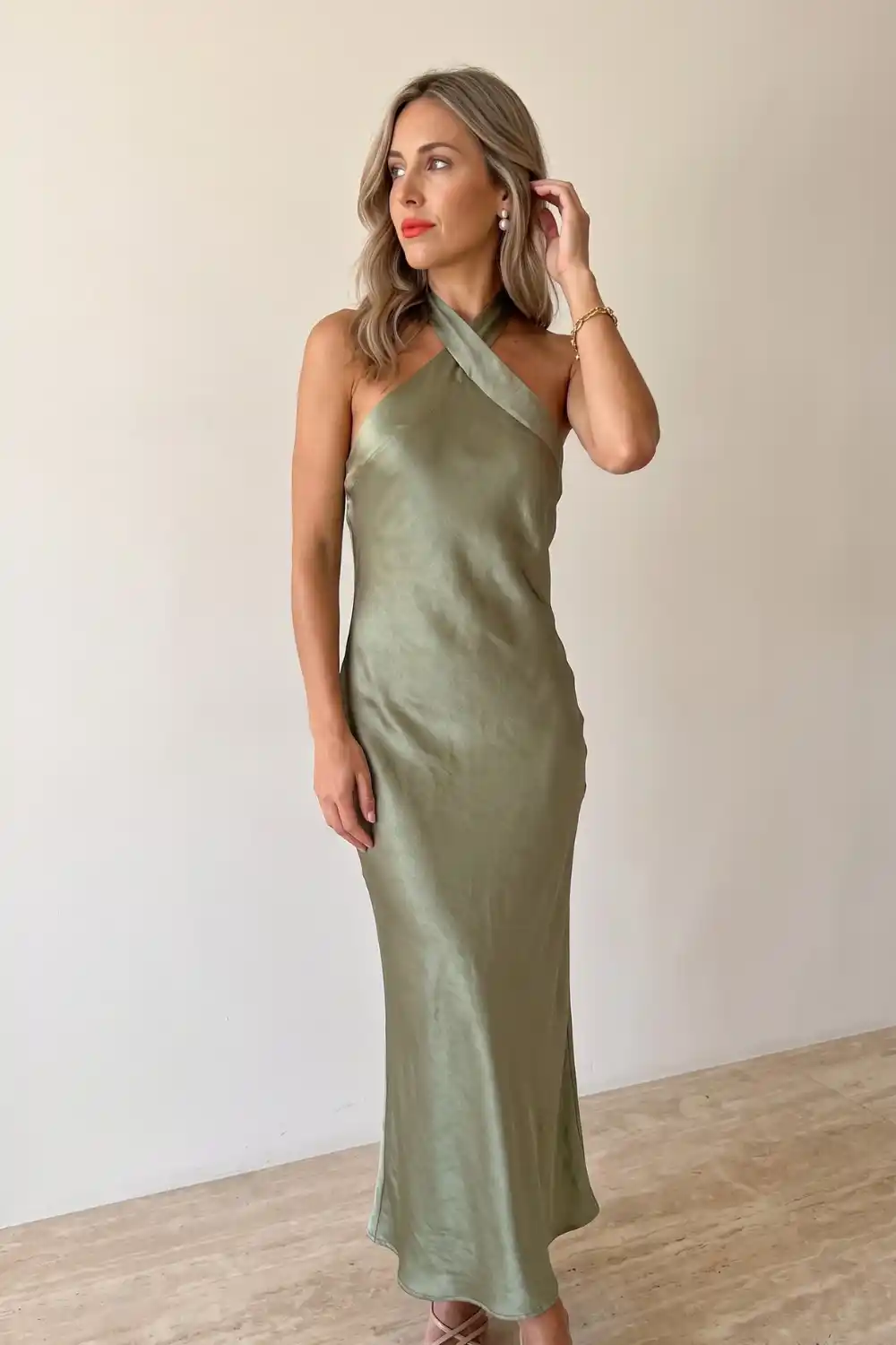 Woman wearing olive green satin halter neck maxi dress