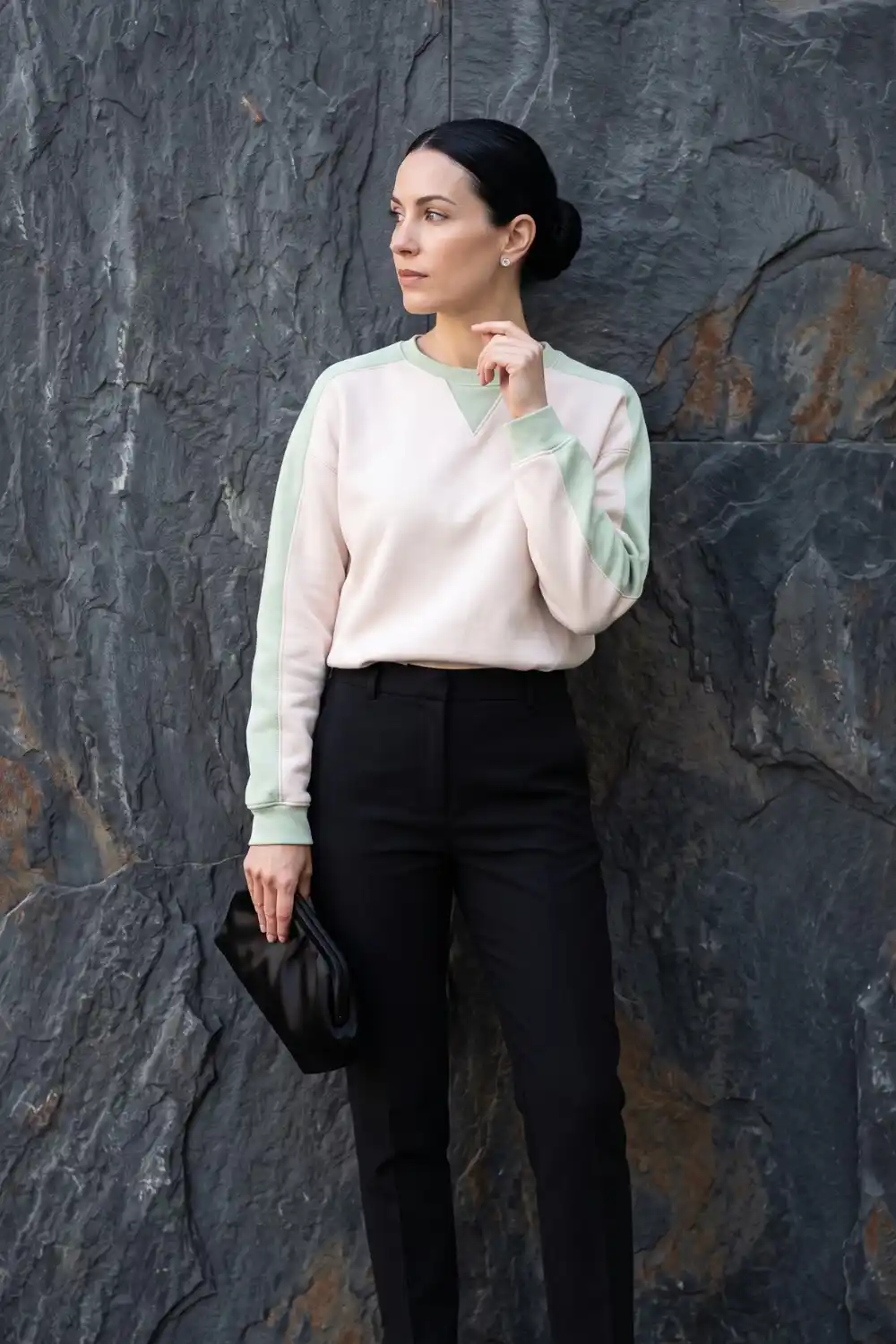 Woman wearing blush pink and mint green colourblock cropped sweatshirt with black trousers