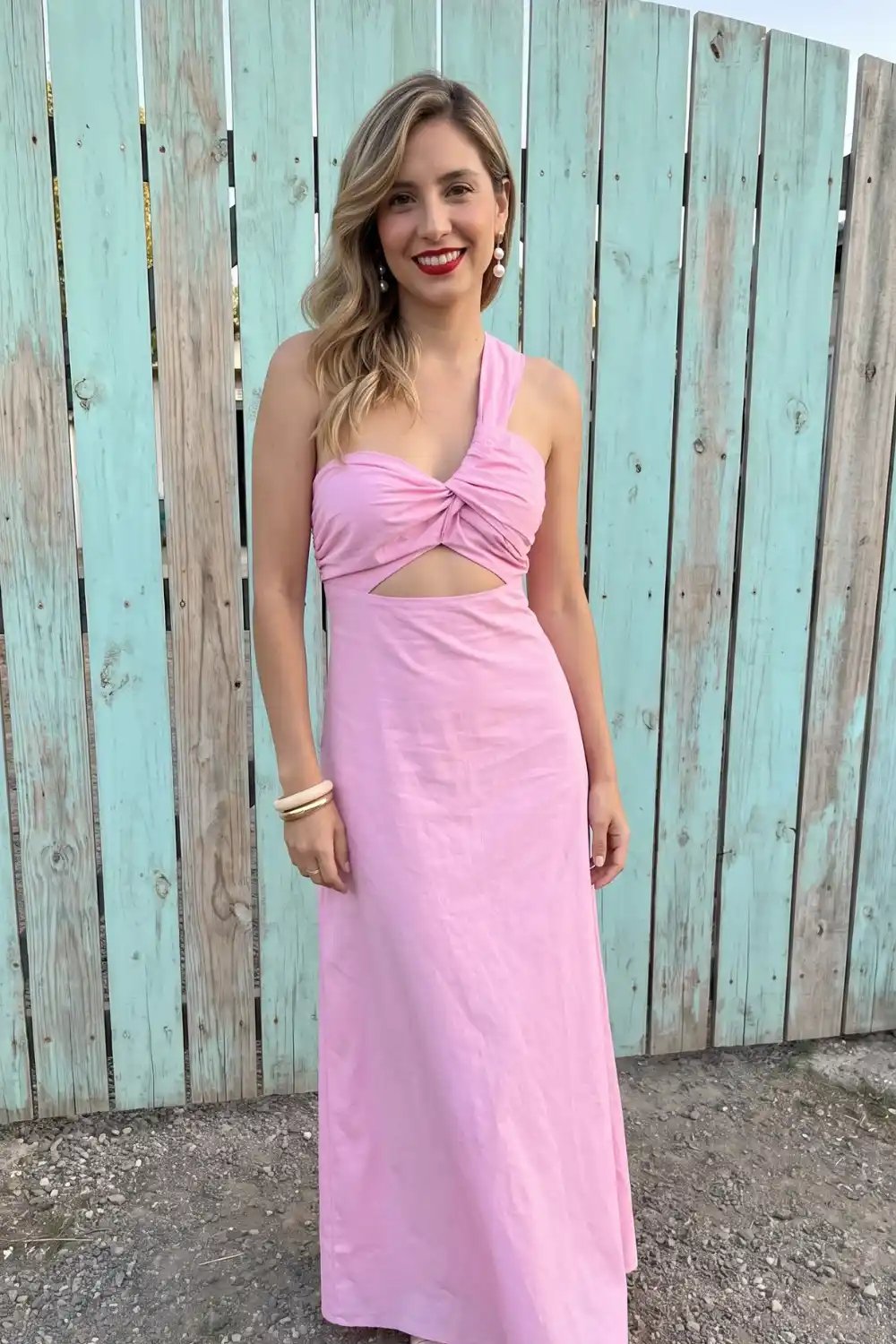 Woman in pink one shoulder twist knot cutout maxi dress