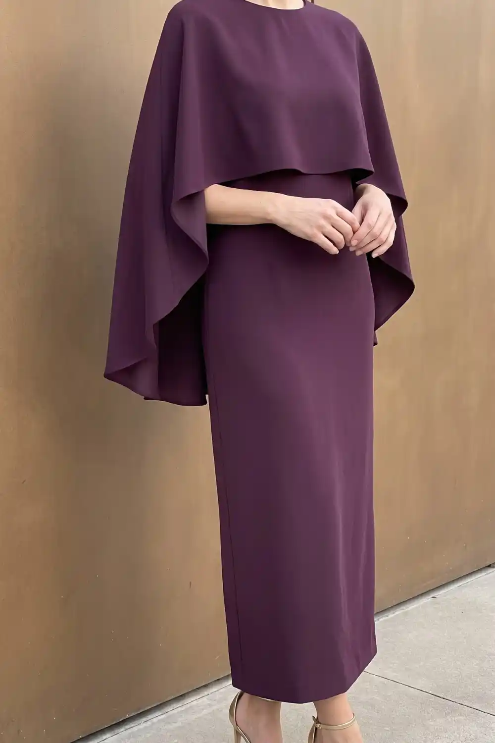 Woman wearing deep plum cape sleeve midi dress