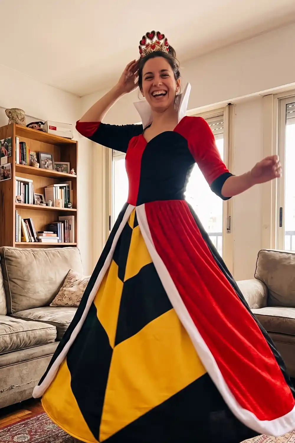 Woman dressed as Queen of Hearts in red black and yellow diamond gown with heart crown