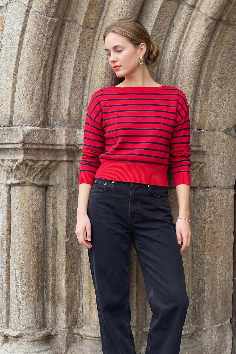 Woman in red navy stripe bateau neck cropped knit sweater with black wide leg jeans