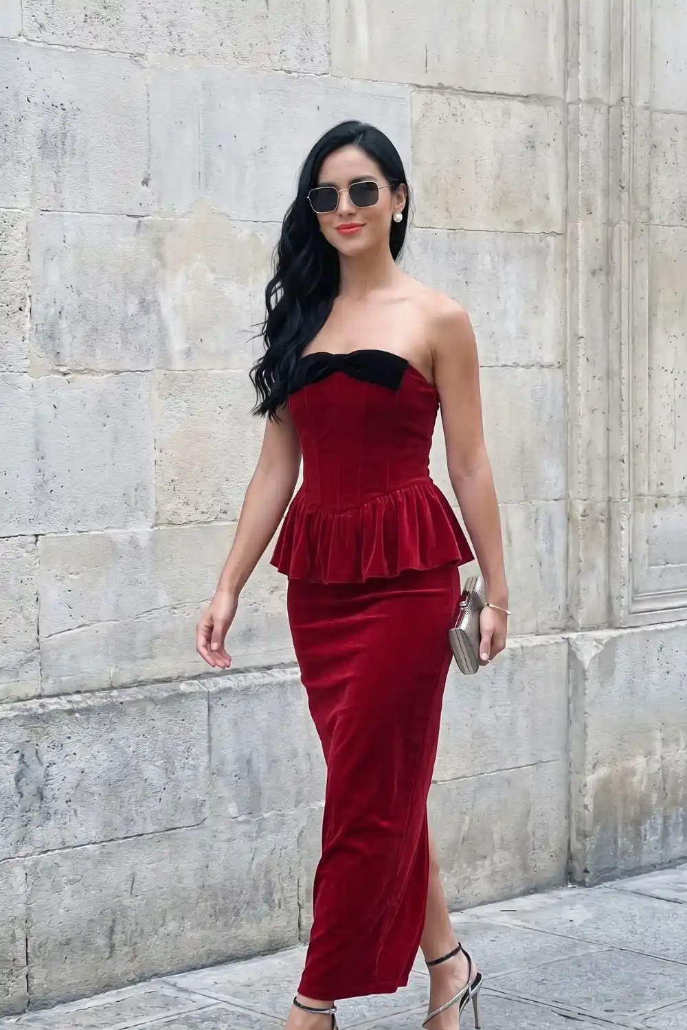 Woman in red velvet strapless peplum midi dress with black bow detail