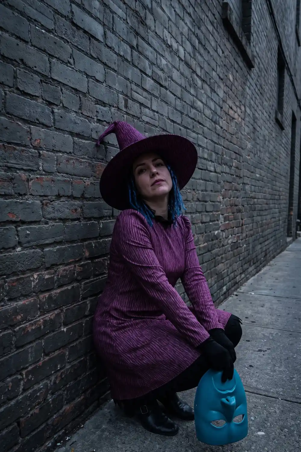 Woman dressed as Shock from Nightmare Before Christmas in purple dress and witch hat