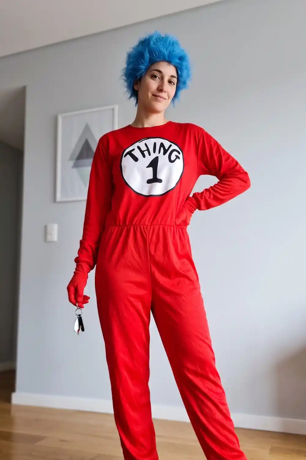 Woman dressed as Thing 1 in red jumpsuit with blue afro wig
