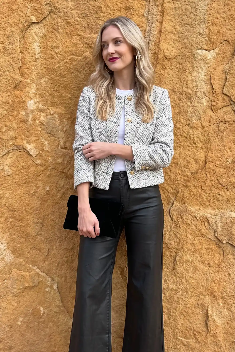 Woman wearing black white tweed cropped jacket with black leather wide leg trousers