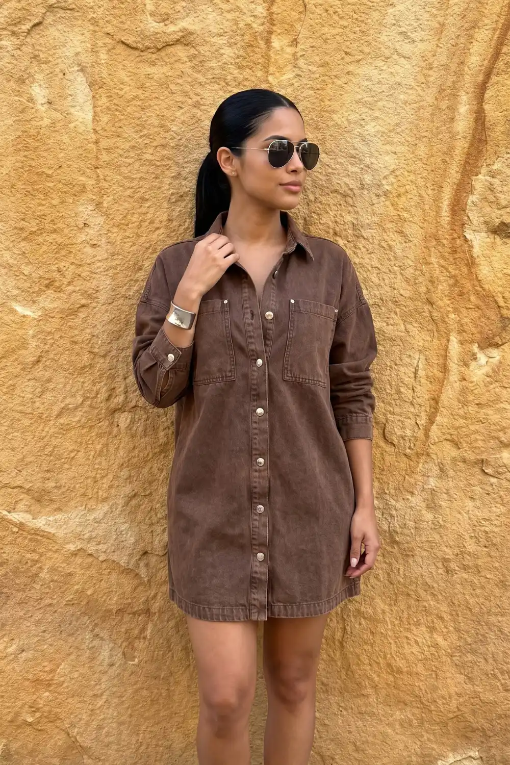 Woman wearing washed brown denim oversized mini shirt dress