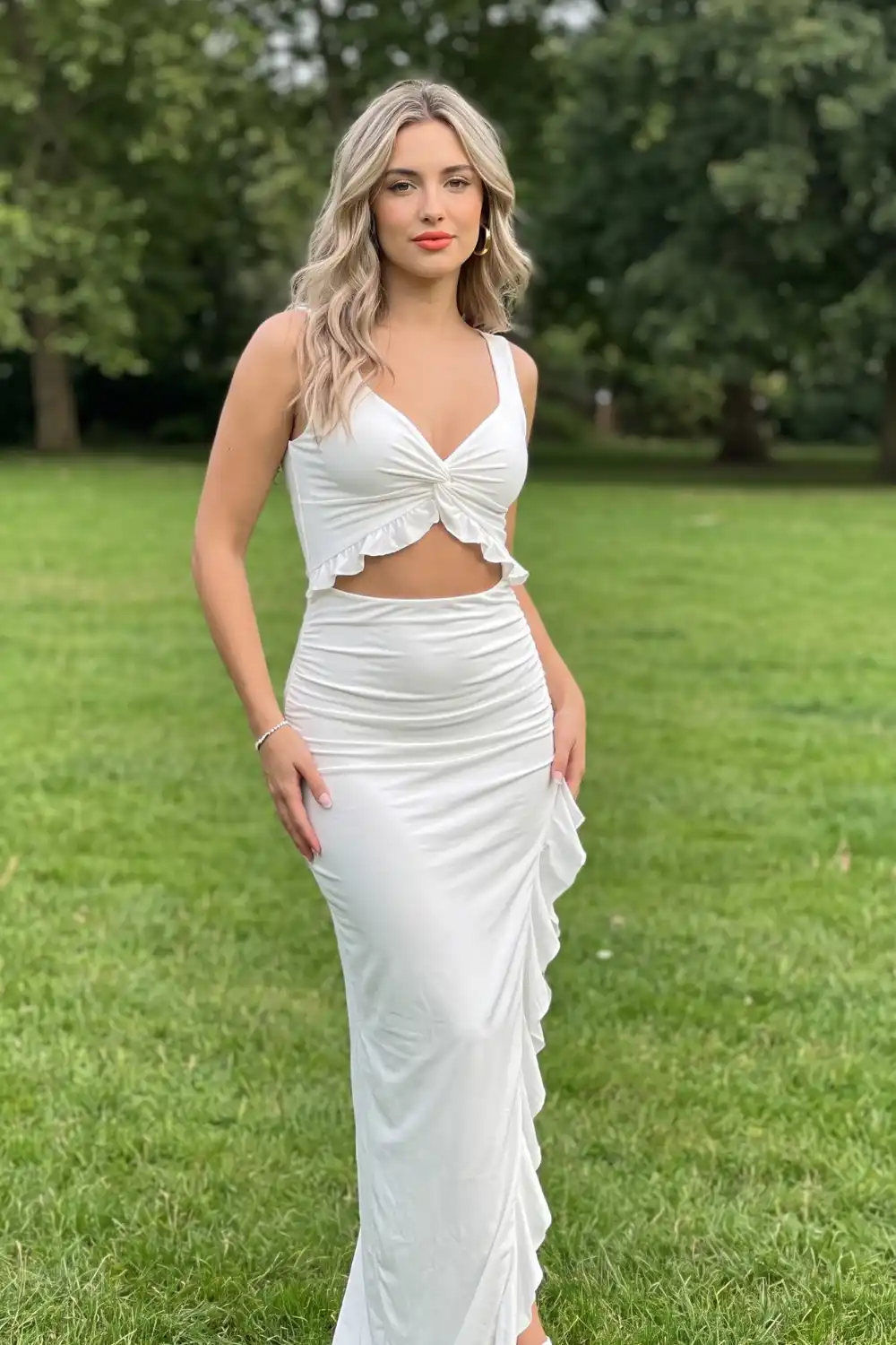 Woman in white twist knot crop top and ruffle maxi skirt set