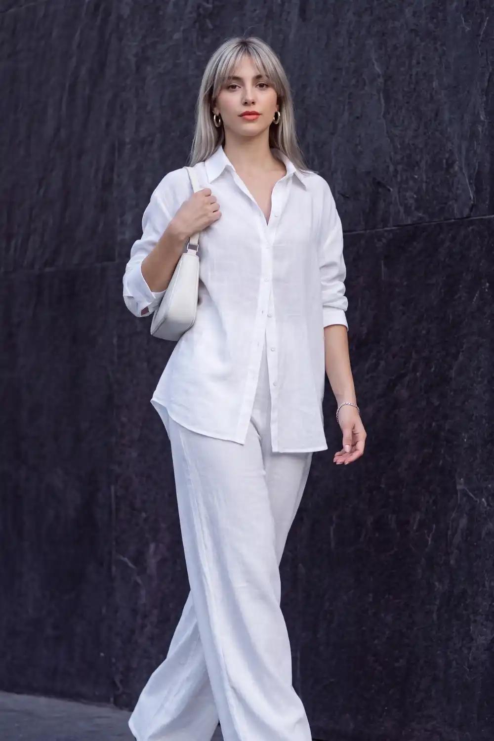 Woman in white linen oversized shirt and wide leg trousers