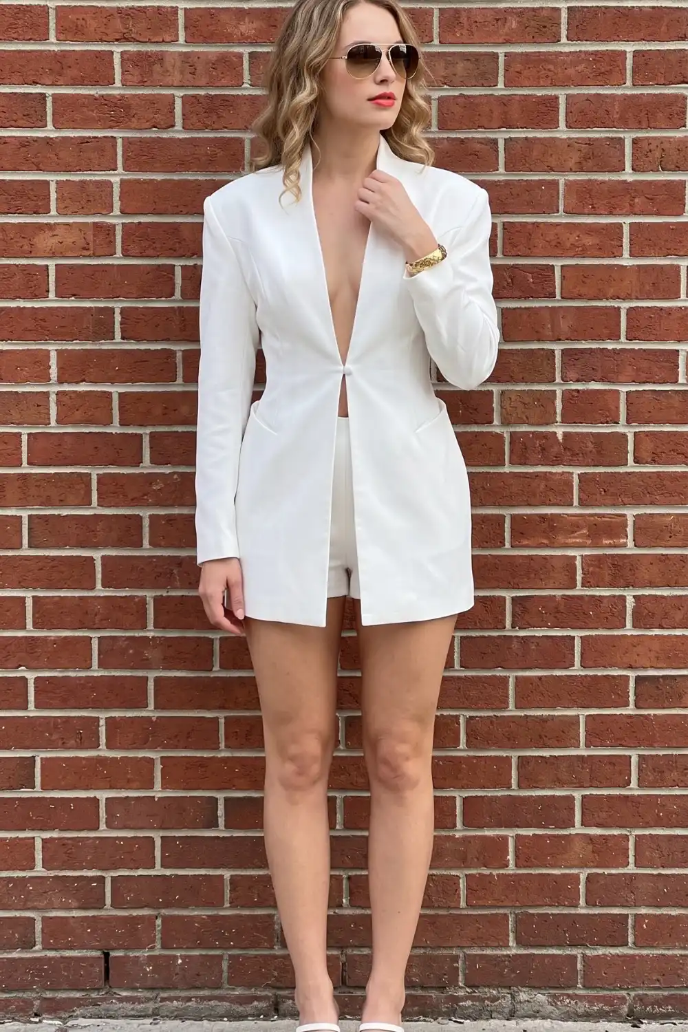 Woman in white longline blazer and white mini shorts