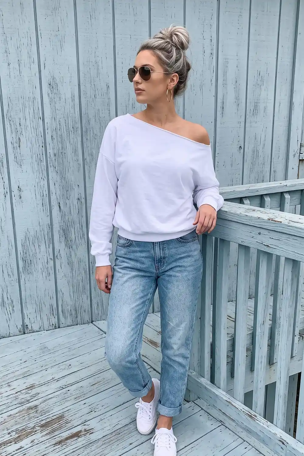 Woman wearing white off-shoulder oversized sweatshirt with mom jeans