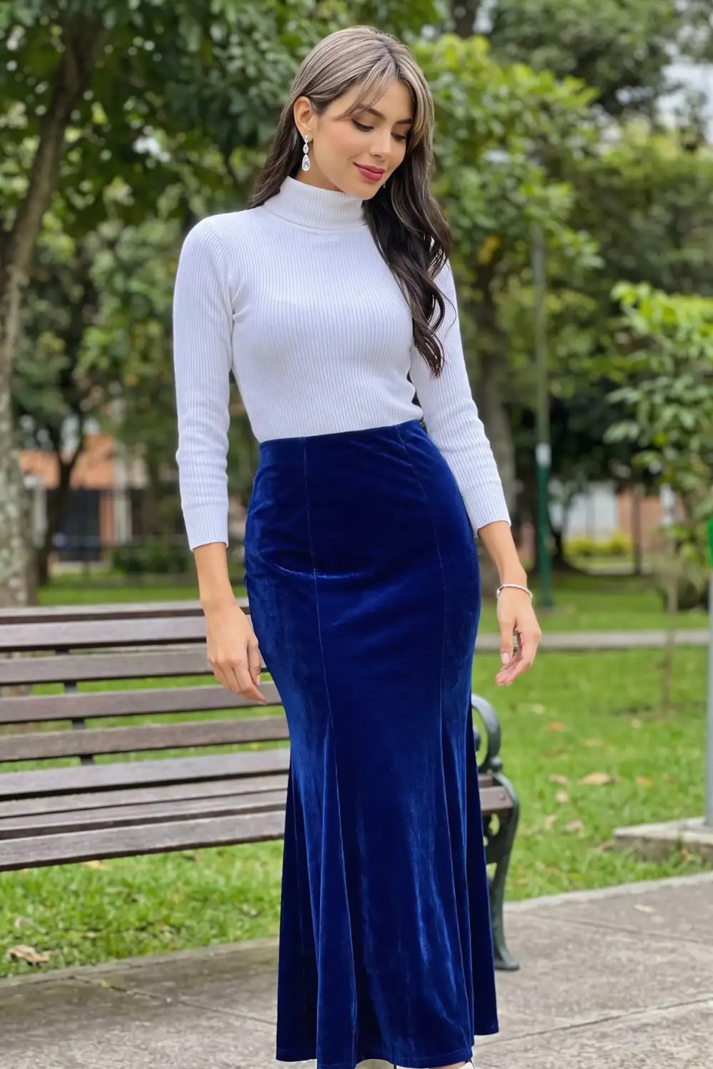 Woman in white ribbed mock neck top with royal blue velvet mermaid maxi skirt