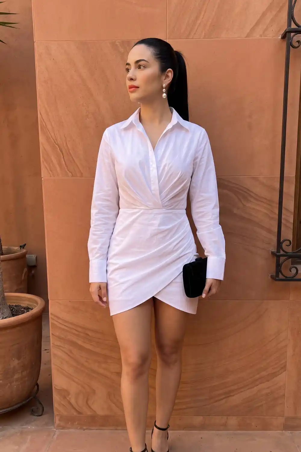 Woman wearing white wrap front ruched mini shirt dress