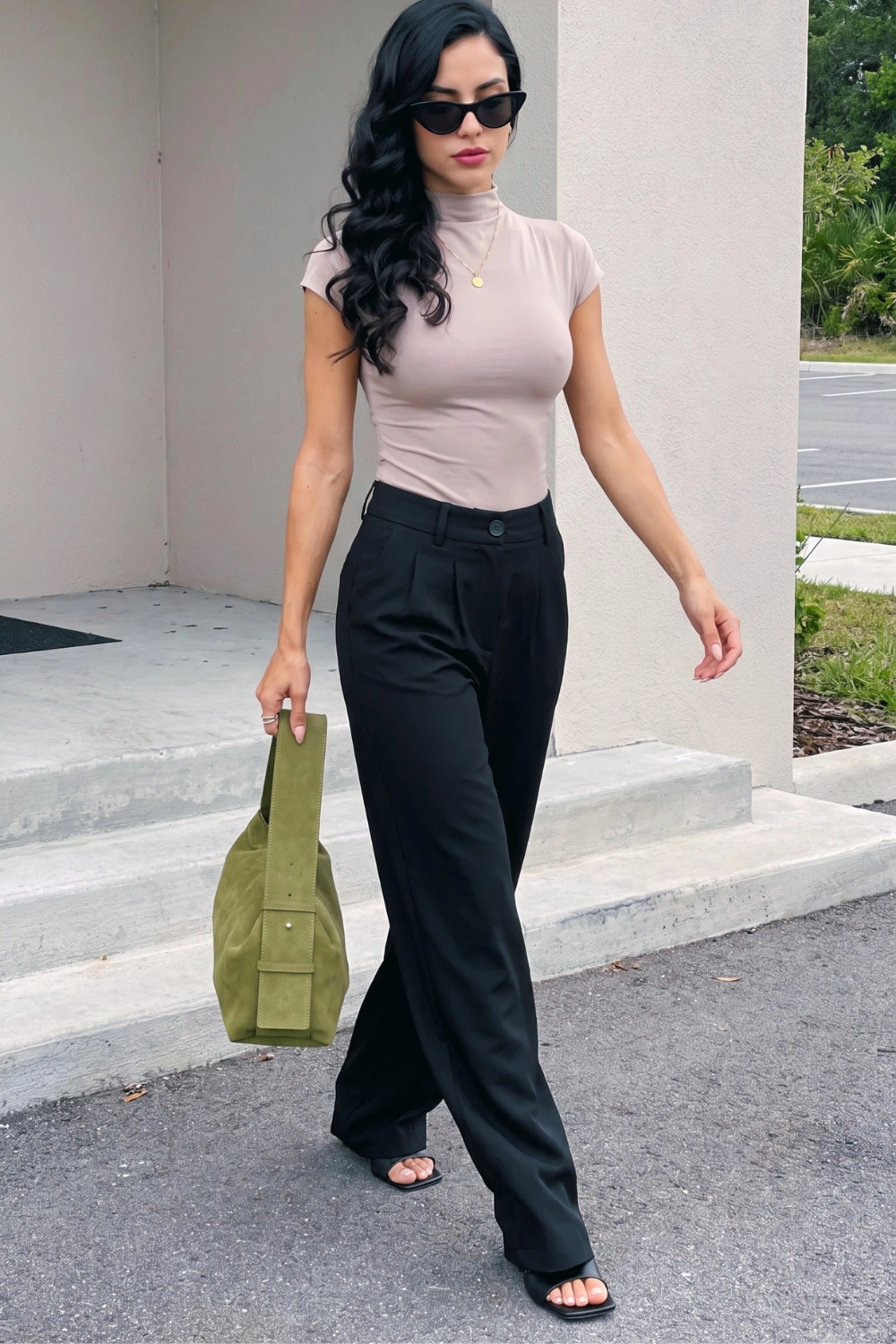 Woman in beige mock neck short sleeve bodysuit with black wide leg tailored trousers