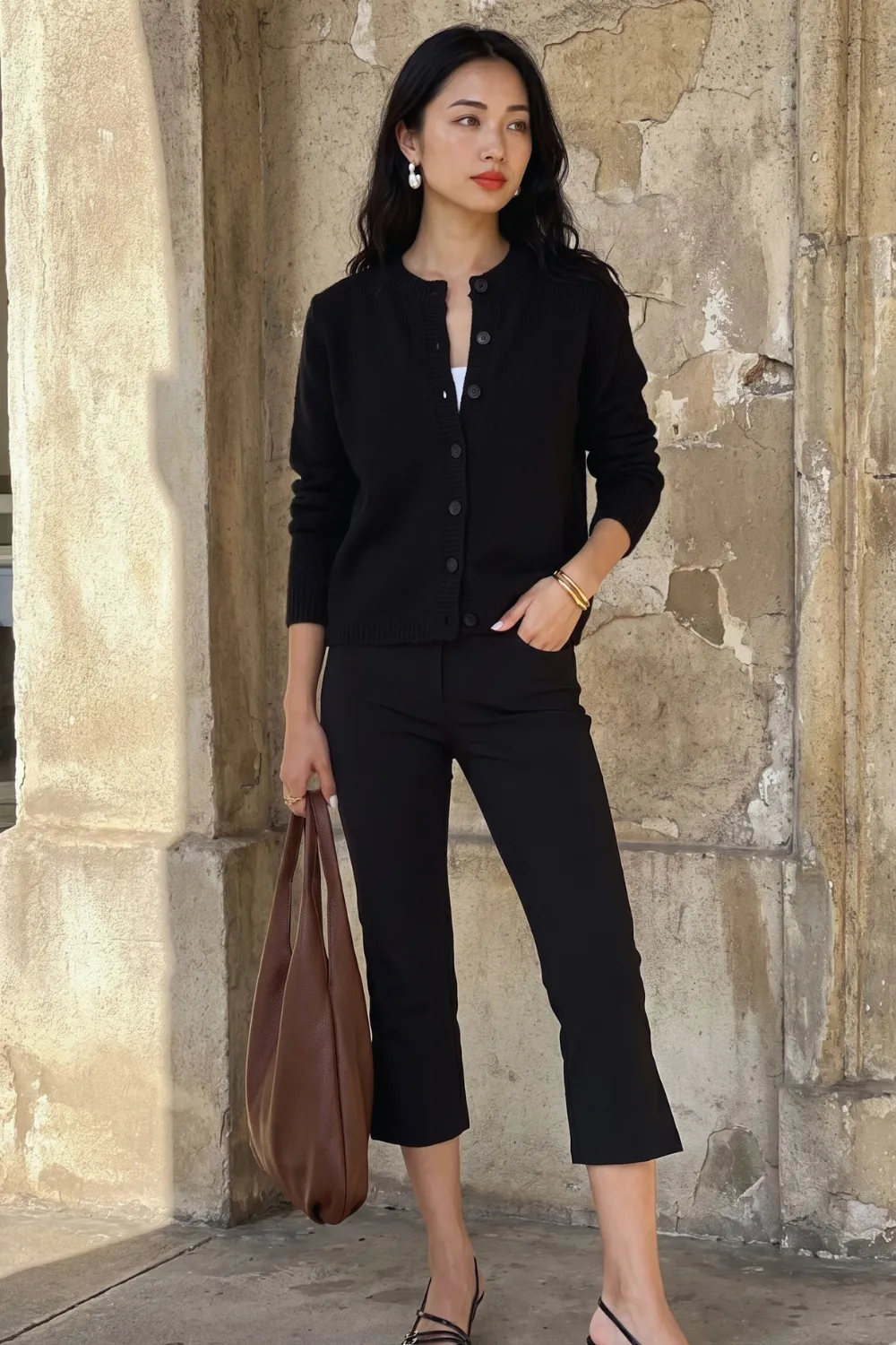 Woman in black cardigan and black cropped trousers