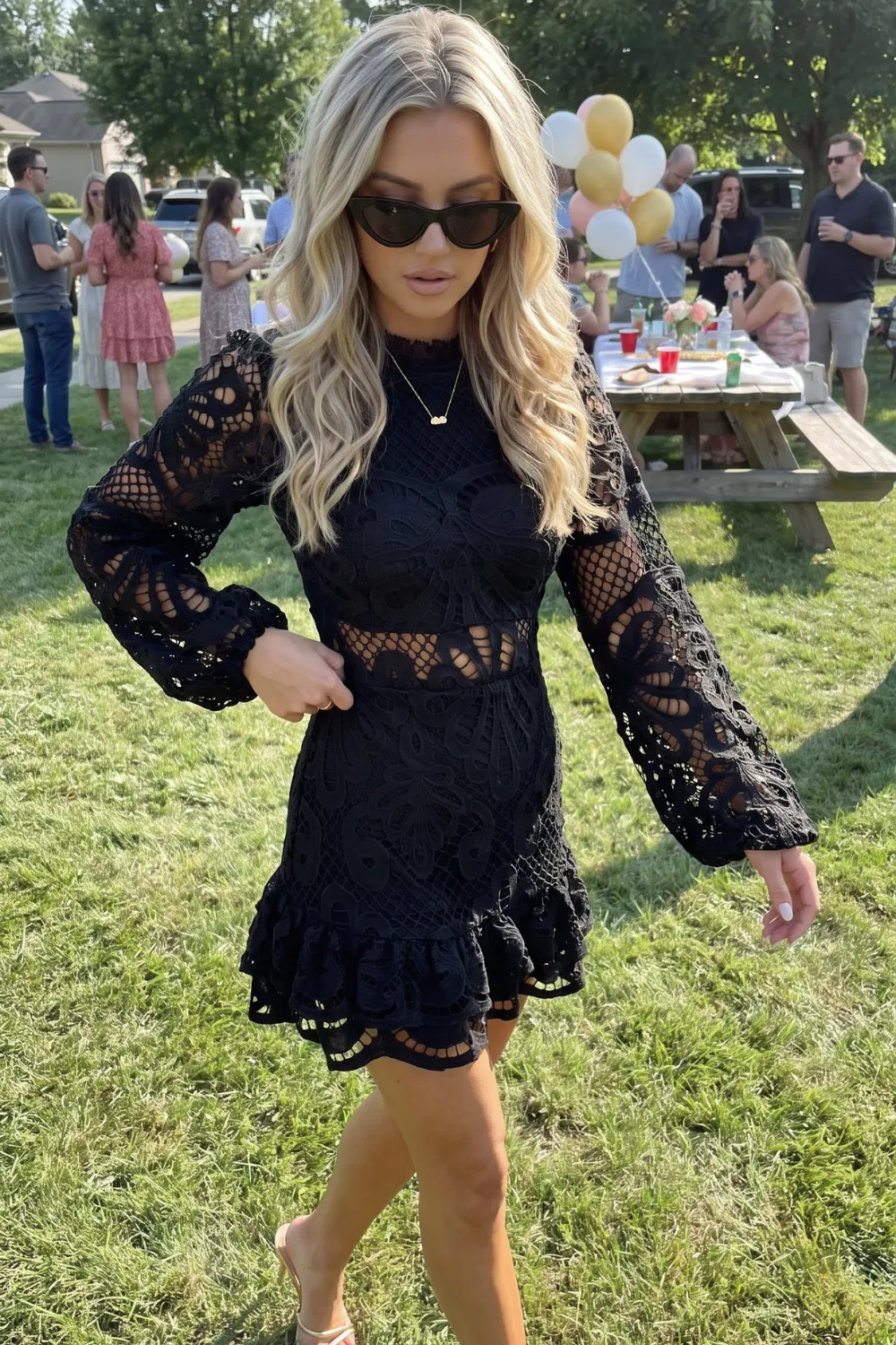 Woman in black crochet lace ruffle hem long sleeve mini dress