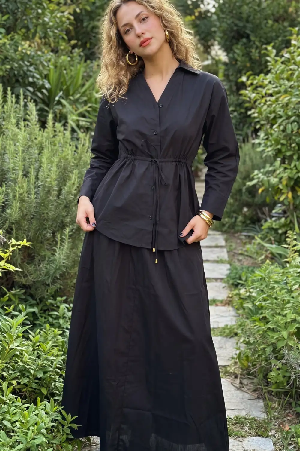Woman in black cotton drawstring waist shirt with black gathered maxi skirt co-ord