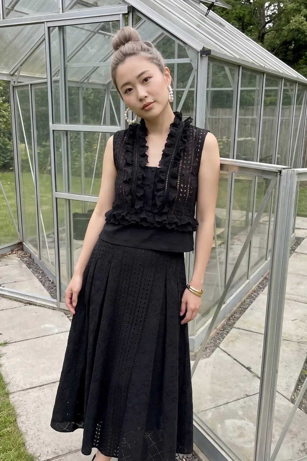 Woman in black eyelet lace ruffle crop top with matching black eyelet lace midi flare skirt