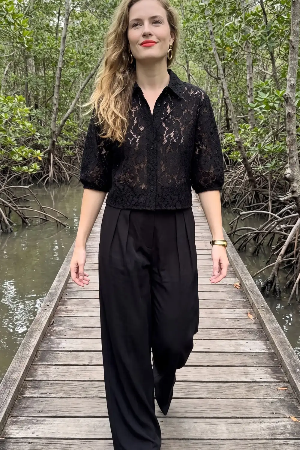 Woman in black sheer lace collared blouse with black wide leg trousers
