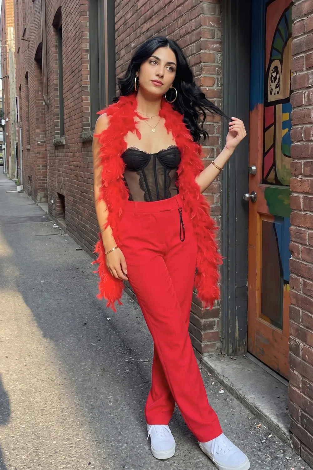 Woman in black sheer lace corset top with red wide leg trousers and red feather boa