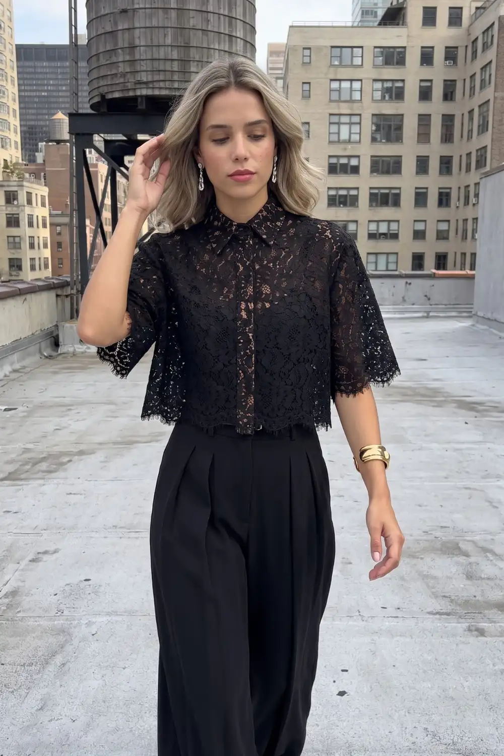 Woman in black sheer lace short sleeve crop blouse with black wide leg trousers
