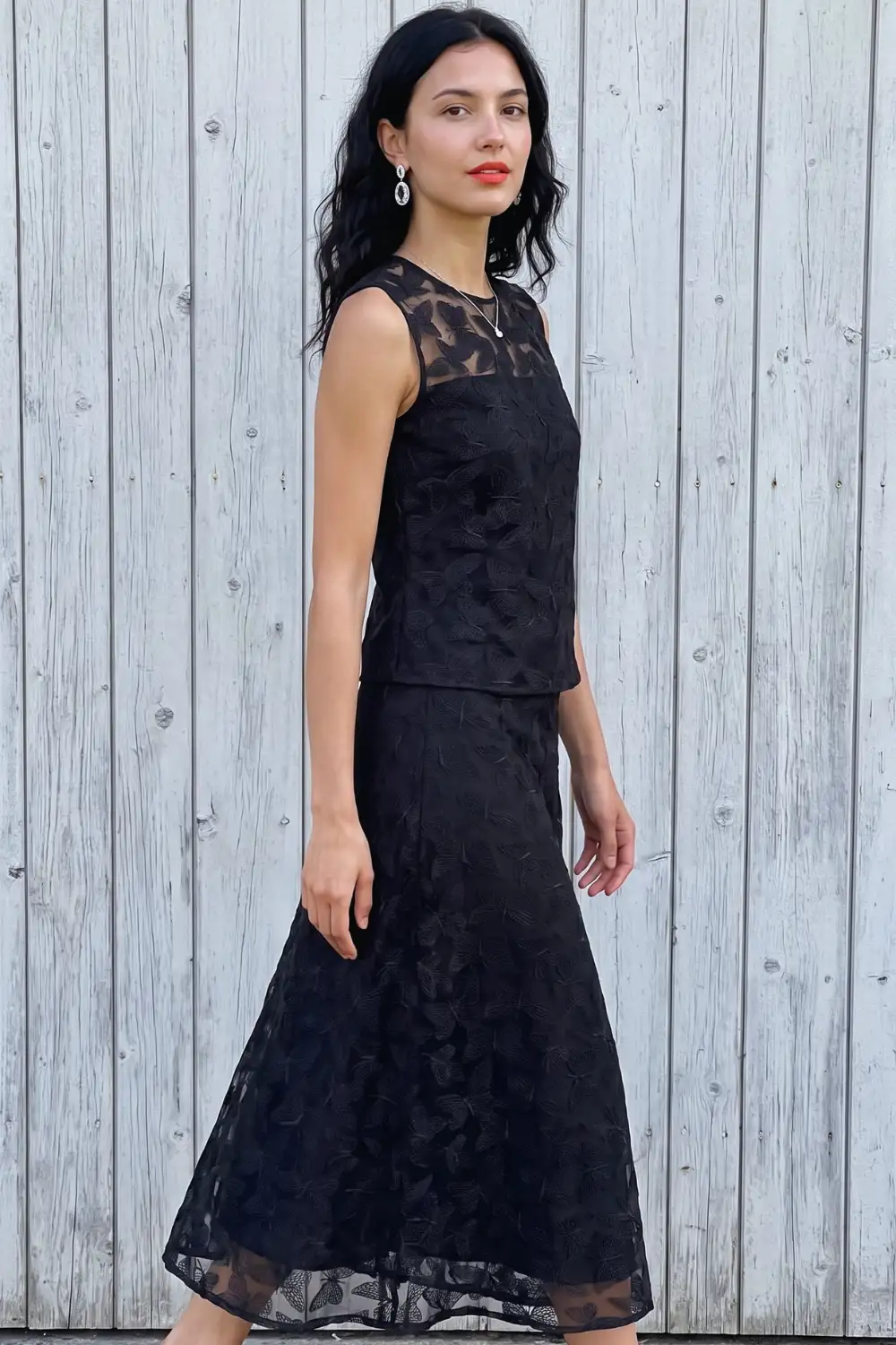 Woman in black sheer floral embroidered lace crop top and matching midi flare skirt