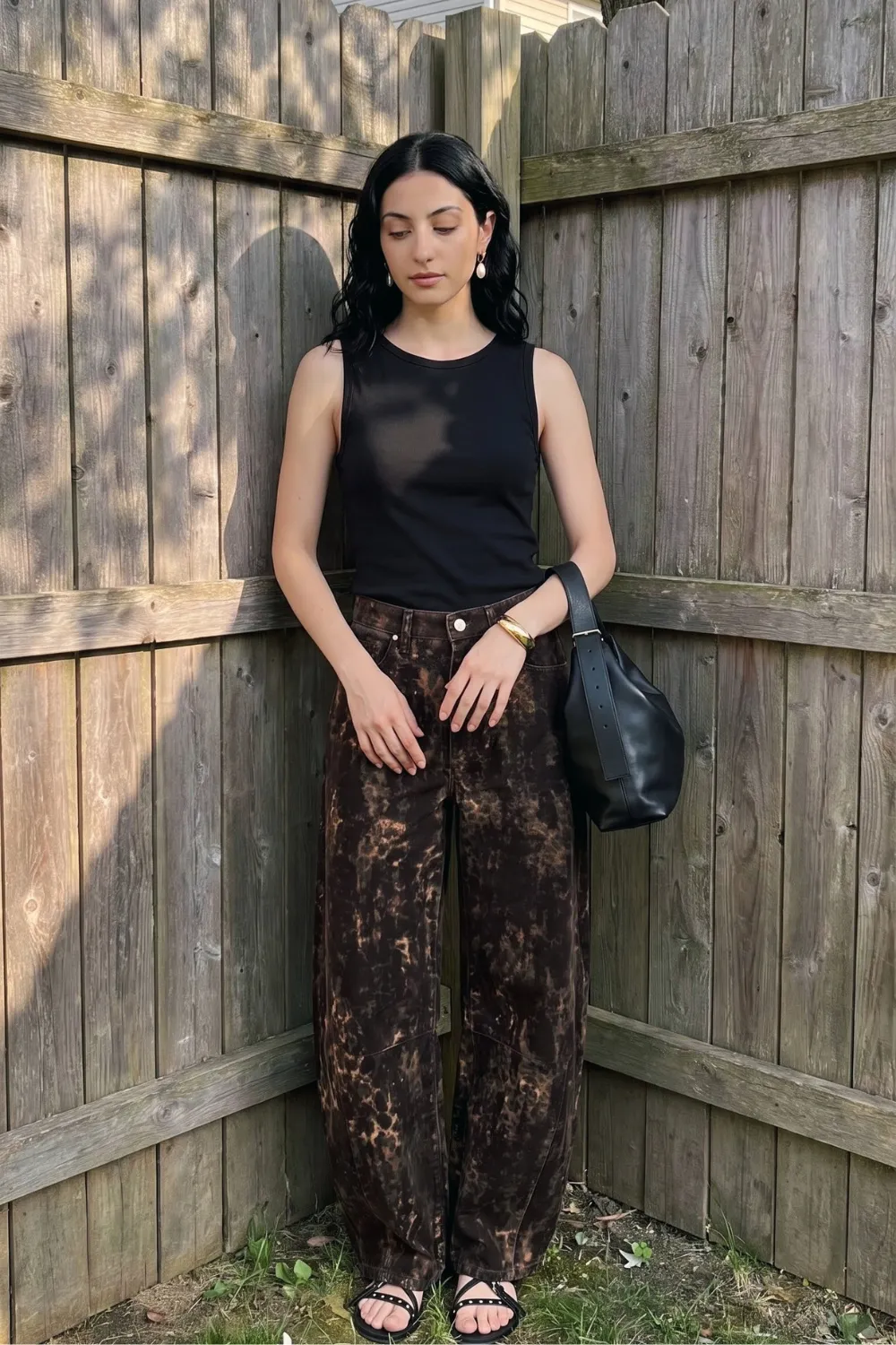 Woman in black sleeveless tank with dark brown acid wash barrel jeans