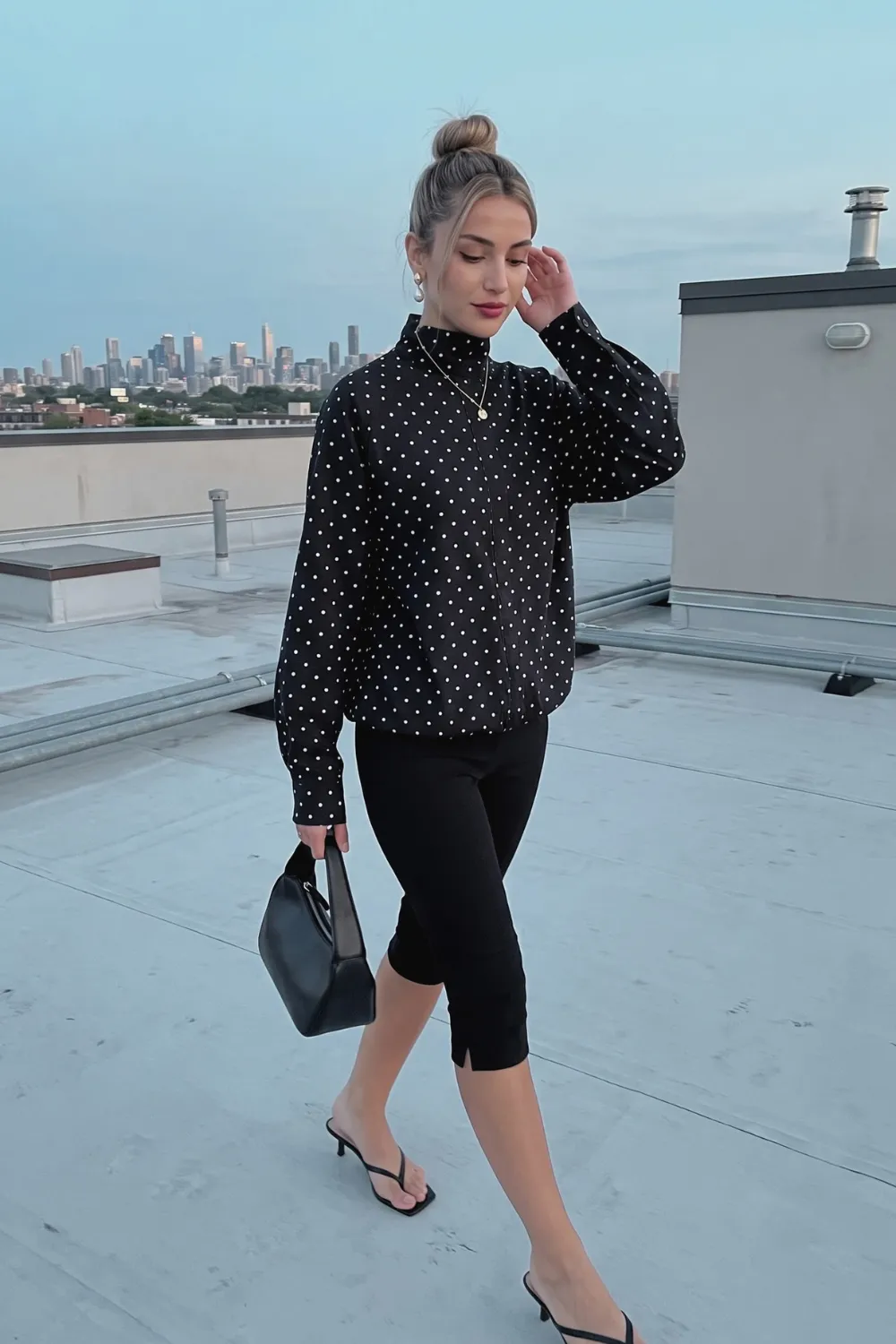 Woman in black white polka dot zip up oversized shirt jacket with black cropped leggings