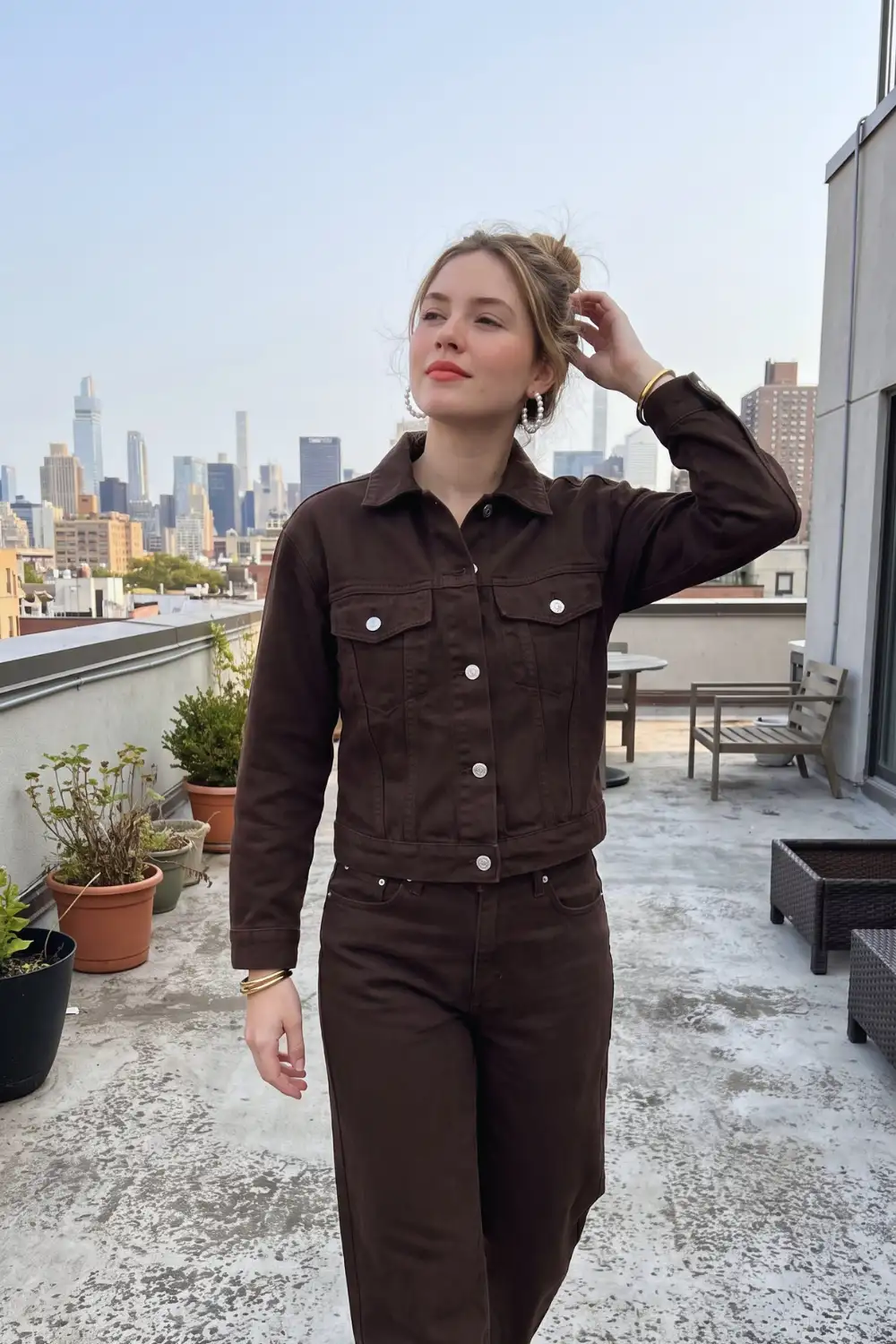 Woman in dark chocolate brown denim trucker jacket with matching straight leg jeans