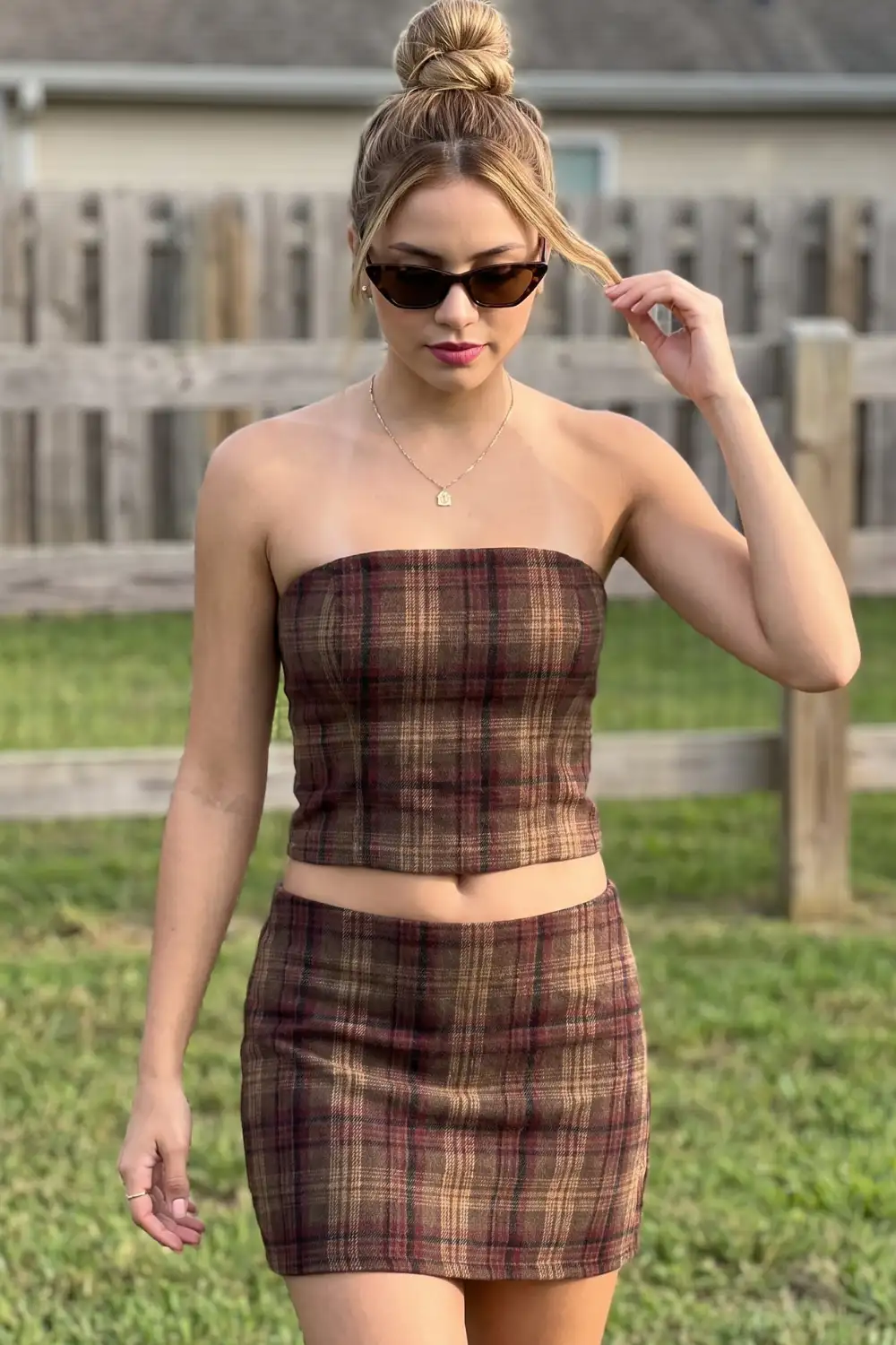 Woman in brown burgundy plaid strapless tube top and matching mini skirt co-ord