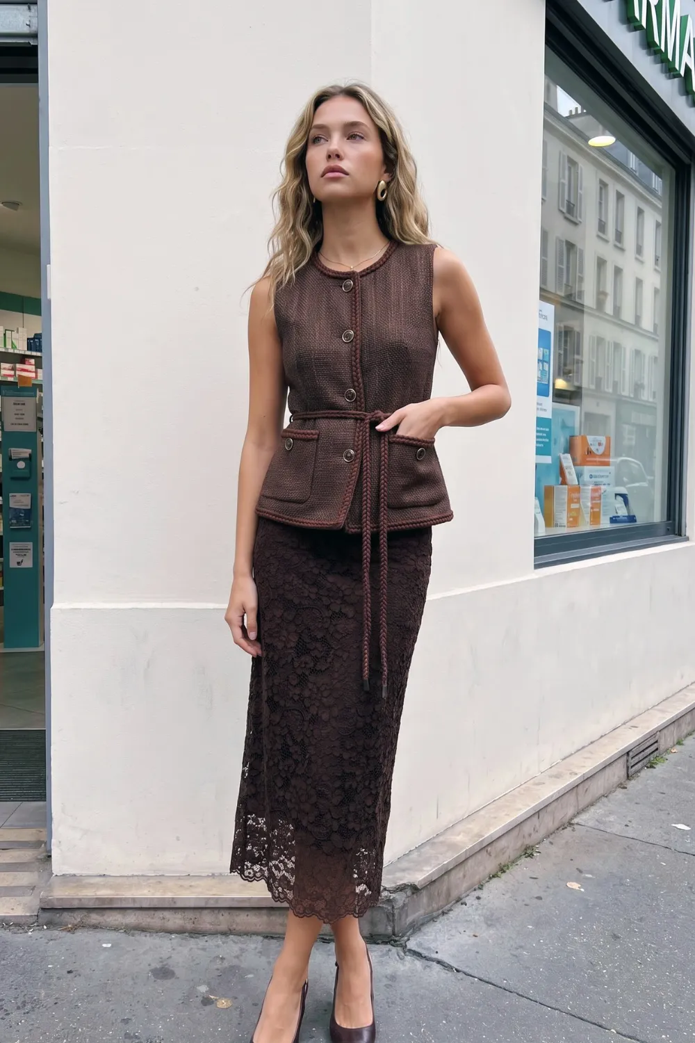 Woman in dark brown tweed braided trim belted sleeveless vest and dark brown lace midi skirt
