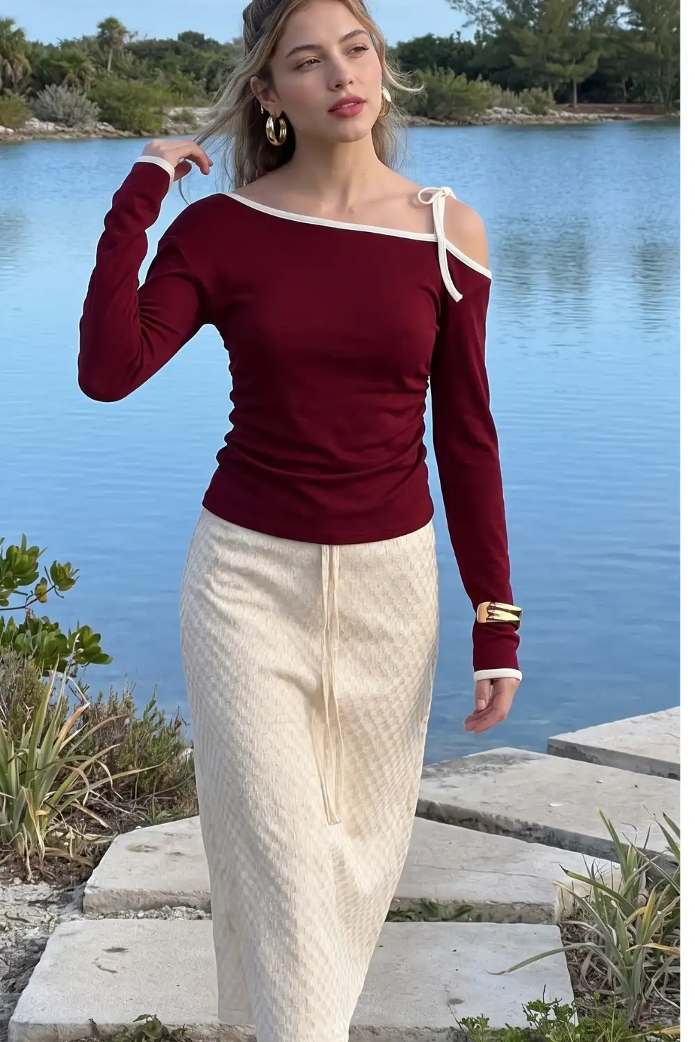 Woman in burgundy cold shoulder bow tie long sleeve top with cream checkered knit midi pencil skirt