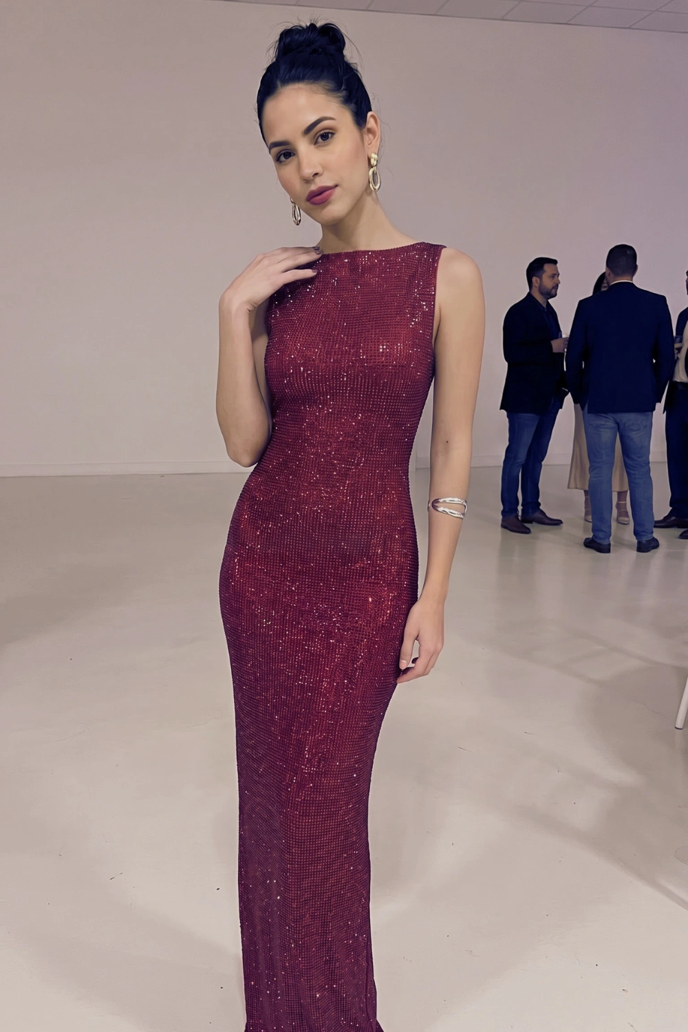 Woman in deep burgundy red sequin sleeveless fitted maxi dress