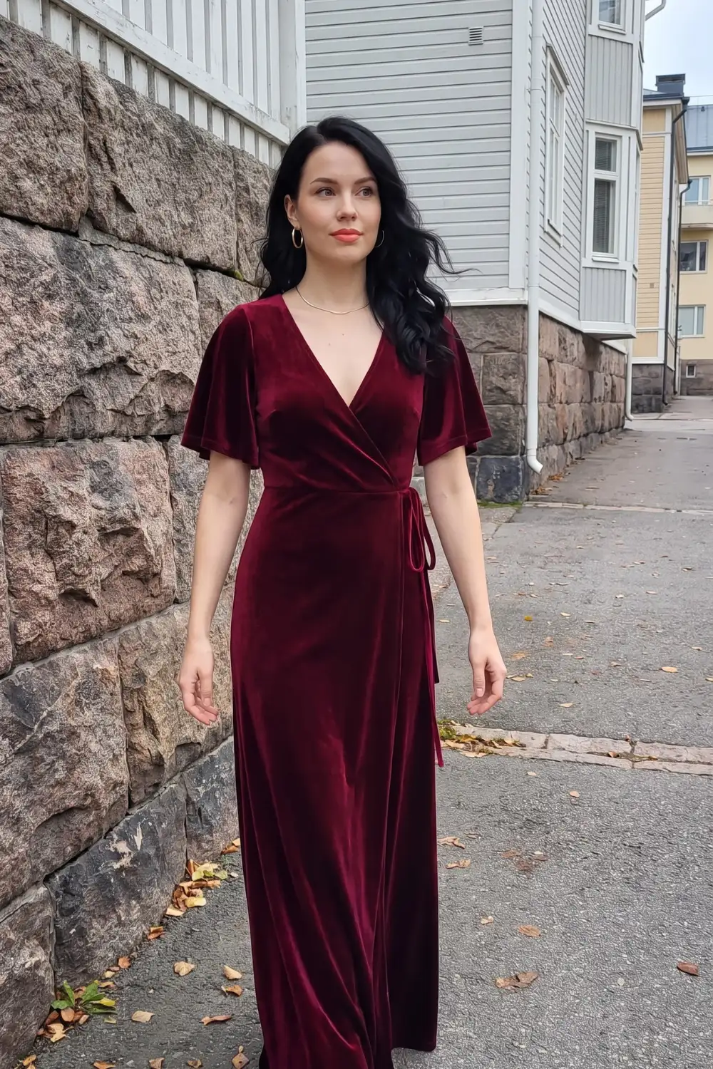 Woman in burgundy velvet flutter sleeve wrap v-neck tie waist maxi dress