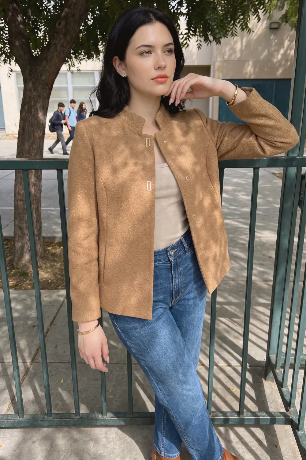 Woman in camel collarless textured blazer with beige tank and blue wide leg jeans
